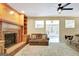 Inviting living room features a brick fireplace and built-in shelves, with neutral carpet and ceiling fan at 110 Greenridge Ct, Fayetteville, GA 30215