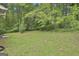 Large backyard with grass, tree coverage, and portion of house visible to the left at 269 Malone Cir, Fairburn, GA 30213