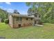 View of backyard brick house featuring sliding glass door with grass and tree coverage at 269 Malone Cir, Fairburn, GA 30213