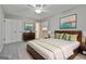 Staged bedroom with a queen bed, ceiling fan, two windows, and a dresser at 269 Malone Cir, Fairburn, GA 30213