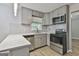 Updated kitchen with stainless steel appliances, gray cabinets, quartz countertop, and mosaic backsplash at 269 Malone Cir, Fairburn, GA 30213