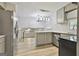 Modern kitchen with stainless steel appliances, light gray cabinets, tile backsplash, and bright light fixtures above the island at 269 Malone Cir, Fairburn, GA 30213