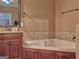 Relaxing soaking tub and beautiful wooden cabinetry in Primary bathroom at 678 Oak Grove Rd, Mcdonough, GA 30253