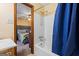 Bright bathroom with shower/tub combo with blue curtain, vanity, and a view into the bedroom at 812 Bartow Ct, Riverdale, GA 30274