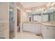 Well-lit bathroom featuring double vanity, granite countertops, and tiled shower at 140 Campaign Trl, Fayetteville, GA 30214