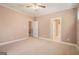 Carpeted bedroom with ceiling fan with two doors and neutral walls in the background at 140 Campaign Trl, Fayetteville, GA 30214