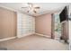 Carpeted bedroom with built-in shelving, a window with curtains, and neutral color scheme at 140 Campaign Trl, Fayetteville, GA 30214