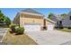 Attached garages with white doors, yellow siding, and a concrete driveway provide ample parking and curb appeal at 140 Campaign Trl, Fayetteville, GA 30214