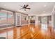 Open-concept living room featuring hardwood floors, ceiling fan, and seamless flow to kitchen at 140 Campaign Trl, Fayetteville, GA 30214