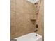 Tiled bathtub featuring a shower with bronze fixtures and a built-in shelf for added convenience at 130 Sycamore Row, South Fulton, GA 30331
