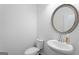 Powder room features a white pedestal sink, brushed nickel faucet and a circular mirror at 1953 Azure Grove Ct, Marietta, GA 30008