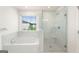 Bright bathroom featuring soaking tub and glass enclosed shower, next to a window at 1953 Azure Grove Ct, Marietta, GA 30008