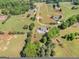 Aerial view showcasing a home with a pool on a vast, green property with mature trees and landscaping at 421 Hampton Rd, Fayetteville, GA 30215