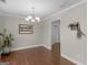This dining room features hardwood floors, light chandelier, and neutral wall colors at 421 Hampton Rd, Fayetteville, GA 30215
