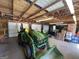 View of garage containing tractor, lawn mower, with wooden ceilings and storage against walls at 421 Hampton Rd, Fayetteville, GA 30215