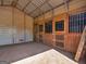 Bright and airy horse stall featuring wooden doors, metal bars, and a well-maintained interior at 421 Hampton Rd, Fayetteville, GA 30215