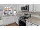 A bright kitchen featuring stainless steel appliances, stone countertops and lots of white cabinets at 421 Hampton Rd, Fayetteville, GA 30215