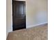 Bedroom with carpet flooring and a dark-stained wooden door with raised panels at 143 Tara Blvd, Loganville, GA 30052