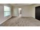 Cozy main bedroom featuring neutral carpet, a window for natural light, and a door to the ensuite at 143 Tara Blvd, Loganville, GA 30052