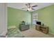 Bright green bedroom features a ceiling fan, large window, and built-in shelves at 103 Fuller Ct, Grantville, GA 30220