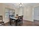 Cozy dining room with elegant chandelier, dark wood table and chairs, and a view of the backyard at 103 Fuller Ct, Grantville, GA 30220