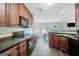 Functional kitchen with rich wood cabinetry, dark countertops, and a seamless view into the adjacent dining area at 103 Fuller Ct, Grantville, GA 30220