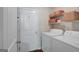 Functional laundry room with white appliances, storage shelves, and a convenient entry door at 103 Fuller Ct, Grantville, GA 30220