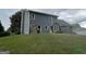 View of the back of the home featuring gray siding, windows, and a well-maintained lawn at 716 Wilkes Dr, Loganville, GA 30052