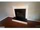 Close up of the fireplace with white mantle, black insert and hearth, in the living room at 716 Wilkes Dr, Loganville, GA 30052