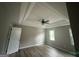 Main bedroom featuring tray ceilings, ceiling fan, and hardwood floors and a large window at 716 Wilkes Dr, Loganville, GA 30052