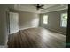 Spacious main bedroom with hardwood floors, tray ceilings, ceiling fan, and natural light at 716 Wilkes Dr, Loganville, GA 30052