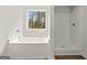 Bright bathroom featuring a bathtub, stand-alone shower, and a view from the window at 3229 Broadnax Mill Rd # 4, Loganville, GA 30052