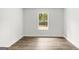 An empty bedroom with wood-look floors and a window, providing natural light and space at 3229 Broadnax Mill Rd # 4, Loganville, GA 30052