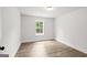 An empty bedroom with wood-look floors and a window, offering natural light at 3229 Broadnax Mill Rd # 4, Loganville, GA 30052
