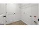 Bright laundry room featuring a white door, wooden floors, and convenient overhead wire shelving at 3229 Broadnax Mill Rd # 4, Loganville, GA 30052