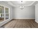 Bright living room featuring new wood floors, large windows, tray ceiling, and stylish chandelier at 3229 Broadnax Mill Rd # 4, Loganville, GA 30052