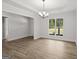 Bright living room featuring new wood floors, large windows, tray ceiling, and stylish chandelier at 3229 Broadnax Mill Rd # 4, Loganville, GA 30052