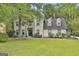 Charming white brick home with a well-manicured lawn and mature trees at 215 Calgary Dr., Peachtree City, GA 30269