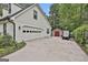 Spacious white garage with driveway, golf cart, and additional storage shed at 215 Calgary Dr., Peachtree City, GA 30269