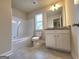 Bathroom features a shower-tub combo, a granite countertop vanity, a window, and tile floors at 542 Hinton Farm Way, Dacula, GA 30019