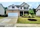 Charming two-story home featuring a brick and siding facade, attached two-car garage, and well-manicured lawn at 542 Hinton Farm Way, Dacula, GA 30019