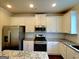 Close-up of a kitchen with stainless steel appliances, granite countertops, and white cabinetry at 542 Hinton Farm Way, Dacula, GA 30019