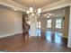 Spacious living area featuring hardwood floors, a modern light fixture, and open access to other living spaces at 542 Hinton Farm Way, Dacula, GA 30019