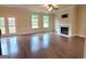 Bright living room with hardwood floors, a cozy fireplace, and access to the backyard through glass doors at 542 Hinton Farm Way, Dacula, GA 30019