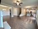 Open-concept living area with hardwood floors leading to a kitchen with white cabinets and stainless appliances at 542 Hinton Farm Way, Dacula, GA 30019