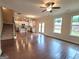 Spacious living room featuring hardwood floors, ceiling fan, and natural light from large windows at 542 Hinton Farm Way, Dacula, GA 30019