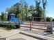 Playground area features a blue playset, a swing set, mature shade trees, and a safety perimeter fence at 542 Hinton Farm Way, Dacula, GA 30019