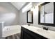 Bathroom with double sink vanity, framed mirrors, bathtub, and wood-look flooring at 146 Calico Loop, Grantville, GA 30220