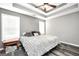Bright main bedroom features a tray ceiling, ceiling fan, and wood-look flooring at 146 Calico Loop, Grantville, GA 30220