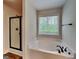 This bathroom offers a corner tub, a large window and a glass-enclosed shower at 147 Tara Blvd, Loganville, GA 30052